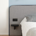Cozy bedroom corner at MIRO Rooms, Riga with modern amenities.