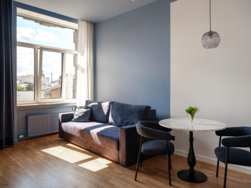 Cozy hotel room at MIRO Rooms, featuring a relaxing sofa and dining table.