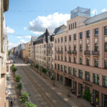 Street view in Riga showcasing local architecture and businesses near MIRO Rooms.